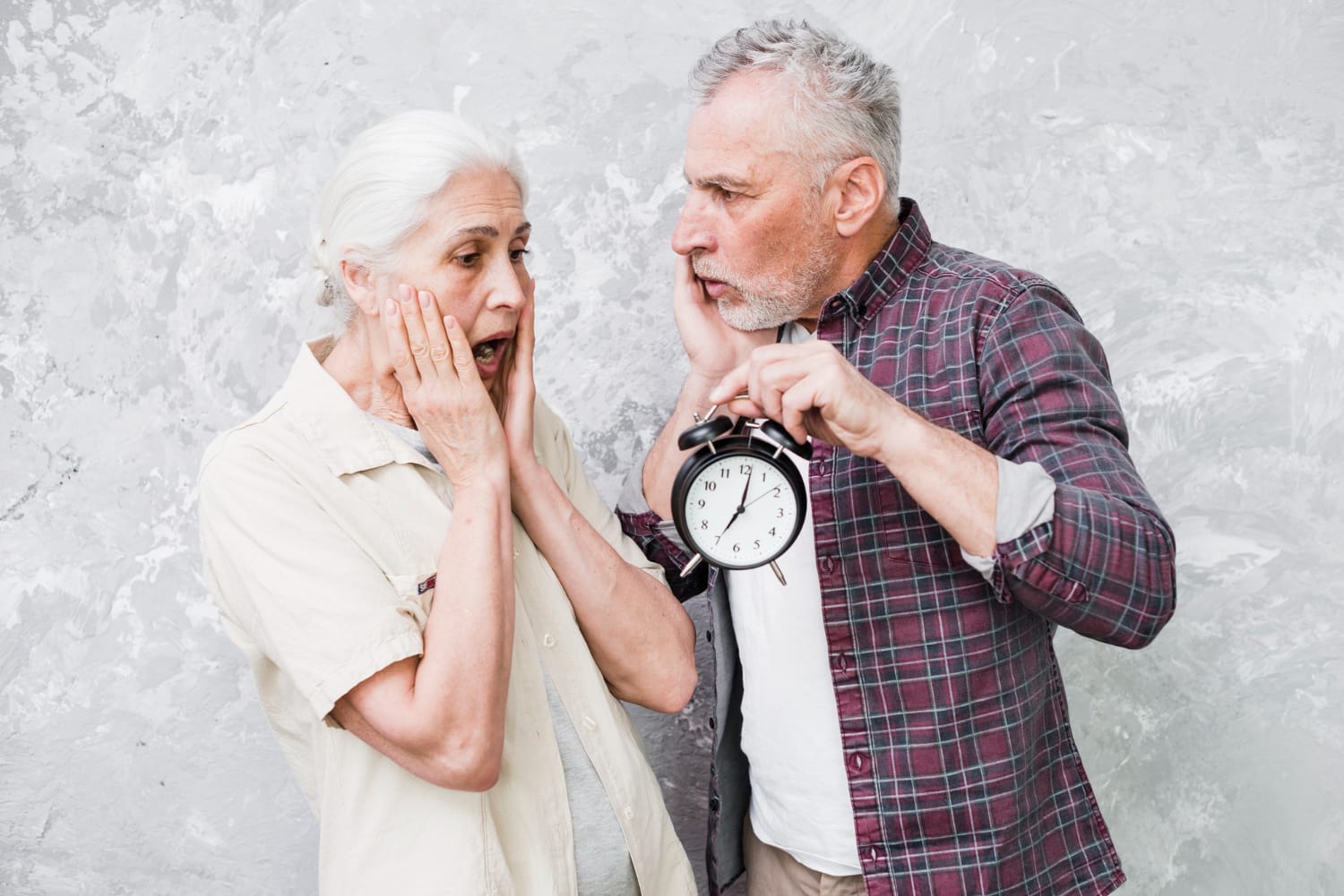 An elderly couple reacts with surprise as the man holds up an alarm clock, creating a humorous scene about time, aging, and urgency.