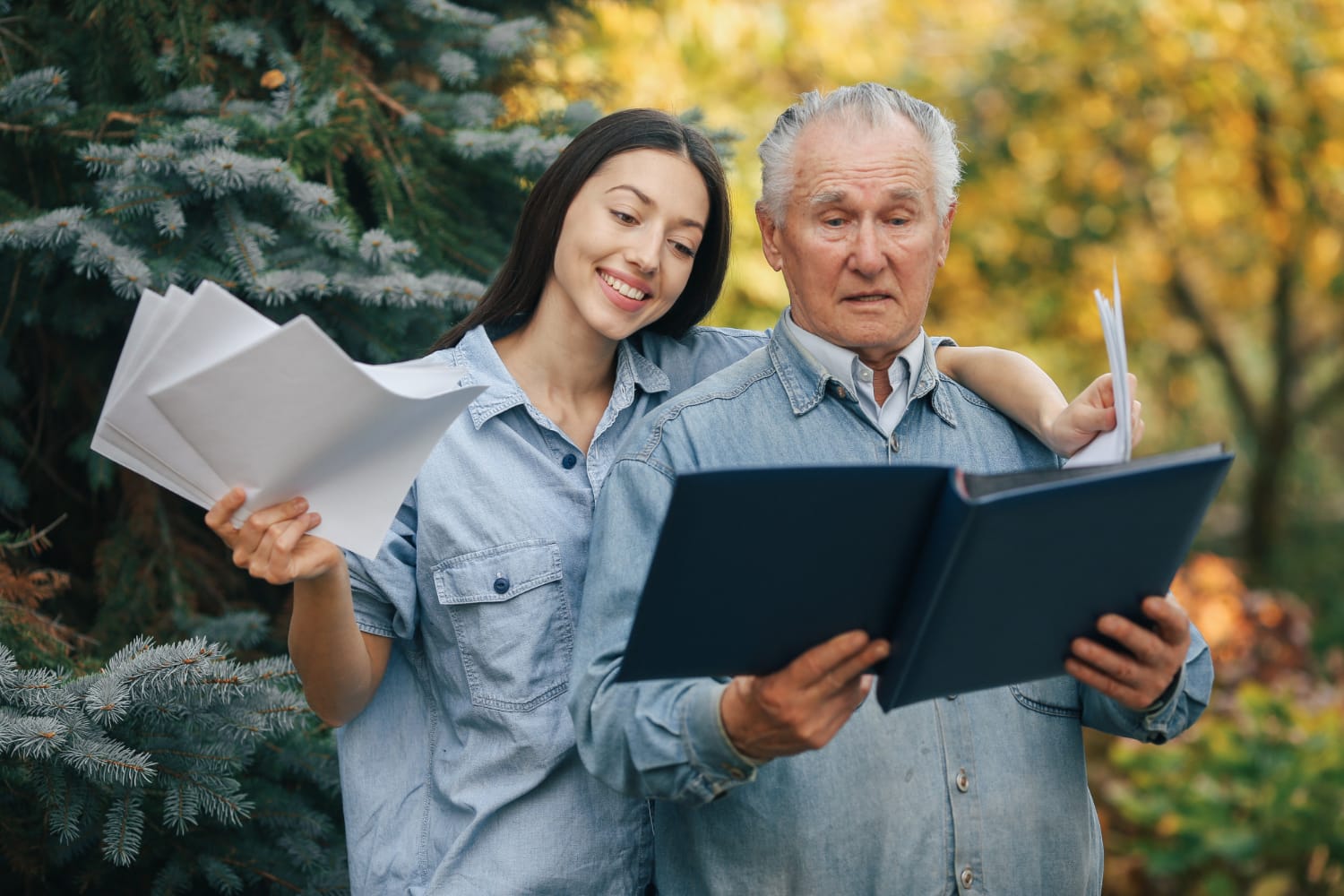 Old man standing in a park backround with his daughter