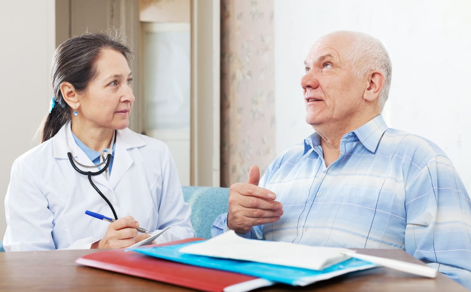 A doctor discusses health concerns with an older man in a medical office.