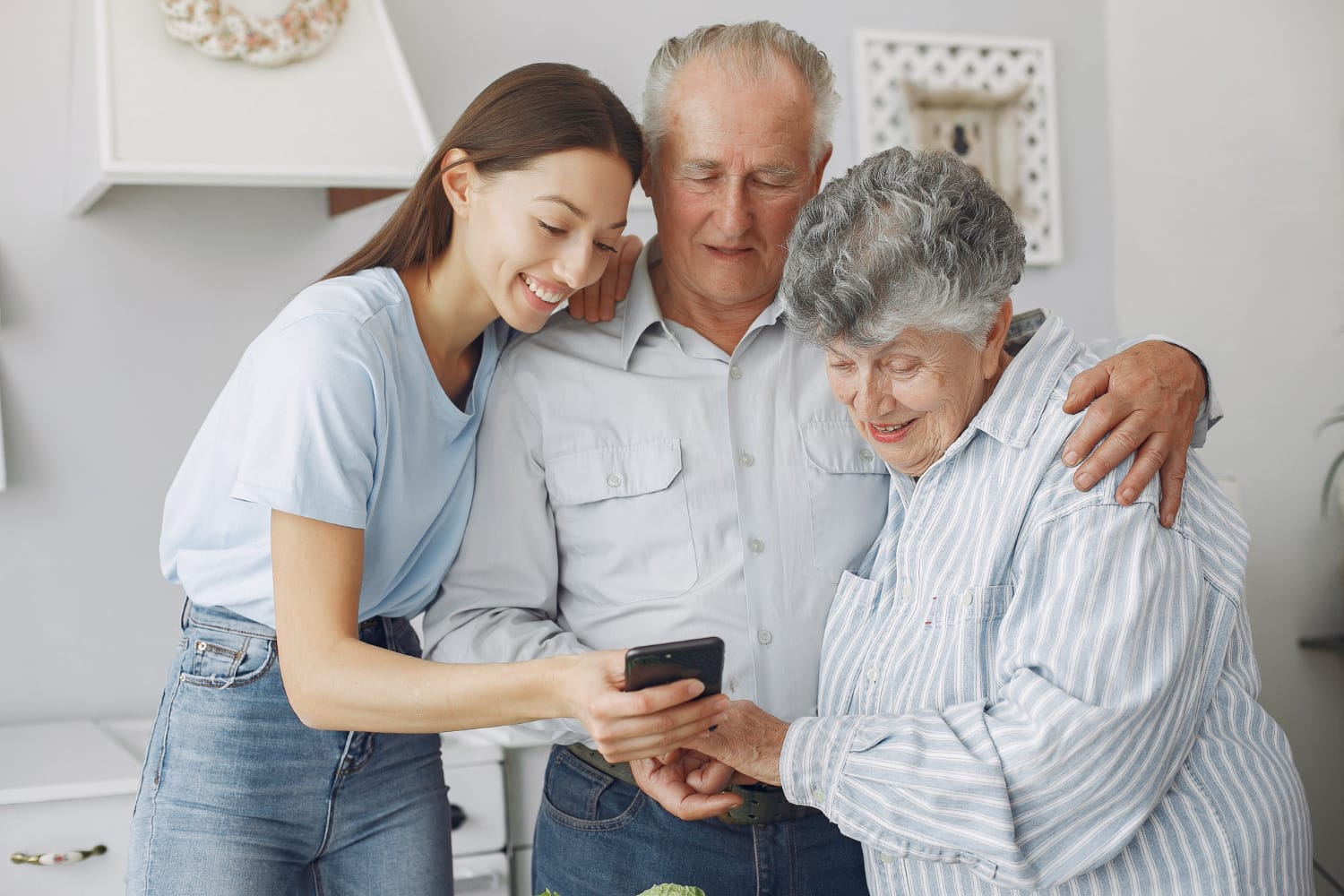 Old couple in a kitchen with young granddaughter