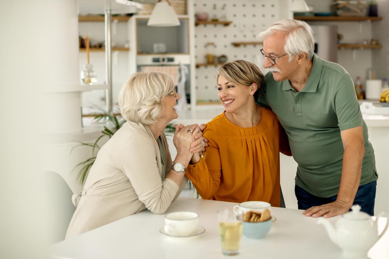 An older couple with their daughter at a table, sharing laughter and conversation.